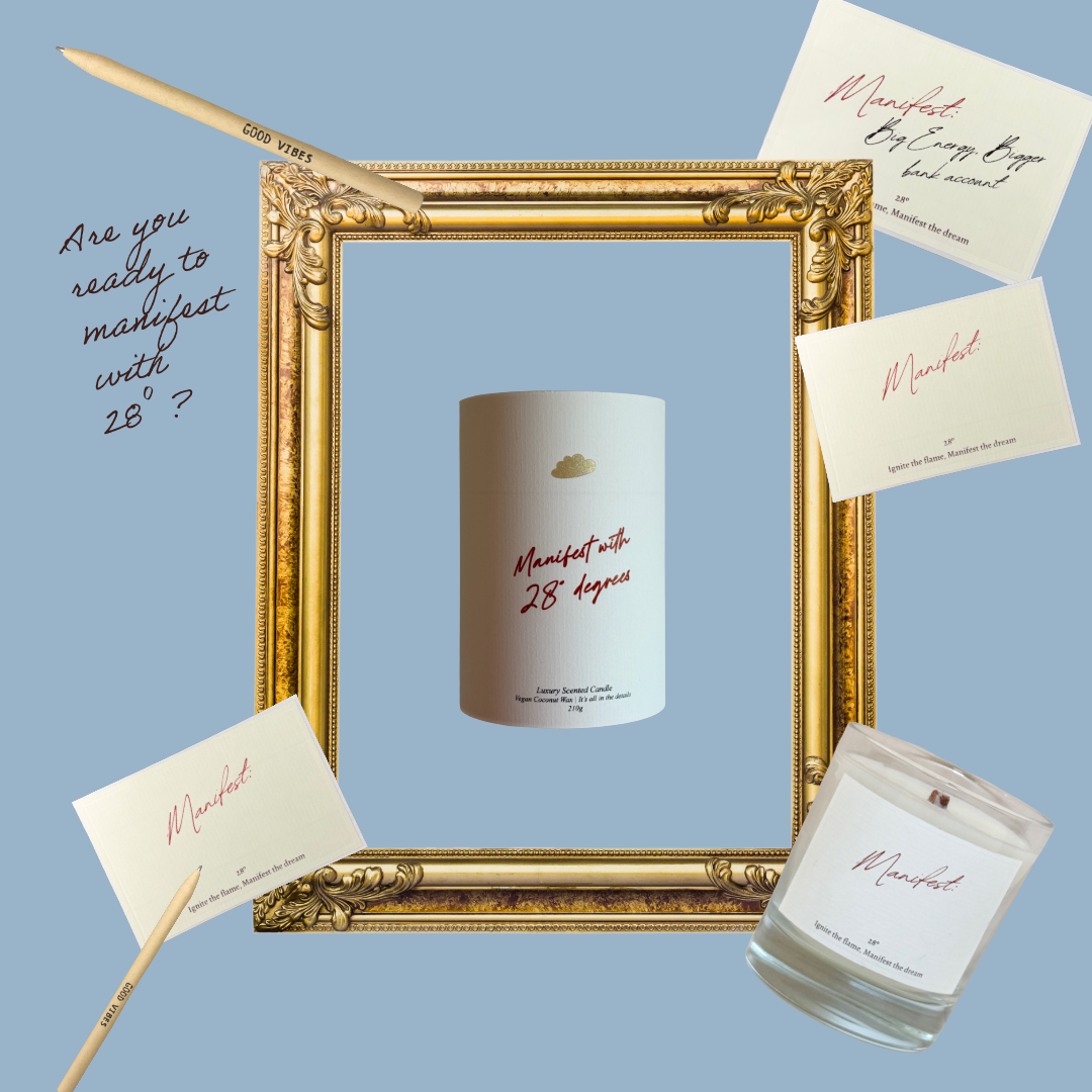 Candle with 'Manifest with 28 degrees' text, gold frame, and cards on a light blue background
