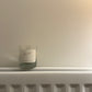 Manifest candle with a blank label to write your own intention on resting on a radiator